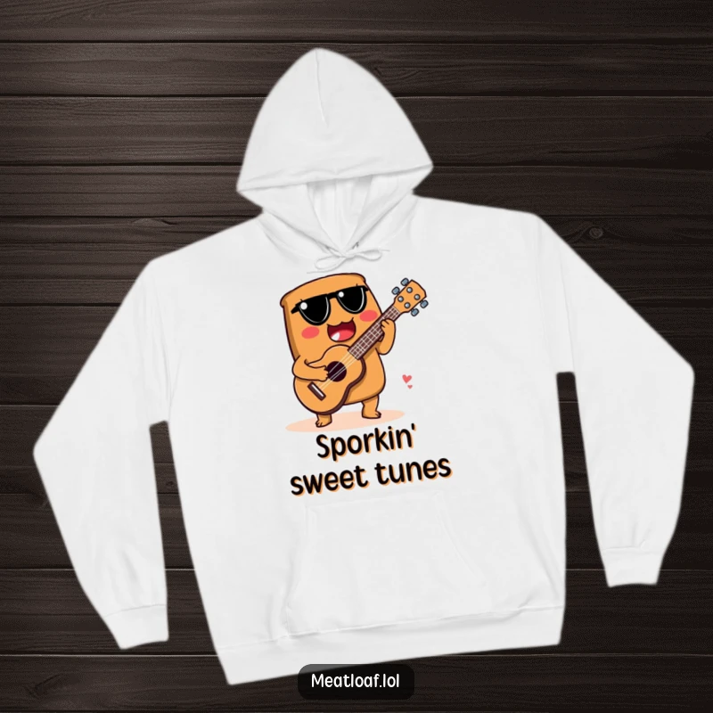 Funny hoodie of a meatloaf character skillfully playing a ukulele fashioned from a spoon, lost in the music.